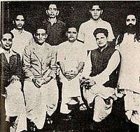 A group photo of people accused in the Mahatma Gandhi murder case. Standing: Shankar Kistaiya, Gopal Godse, Madanlal Pahwa, Digambar Badge (Approver). Sitting: Narayan Apte, Vinayak D. Savarkar, Nathuram Godse, Vishnu Karkare